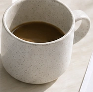 Coffee on a light wood desk
